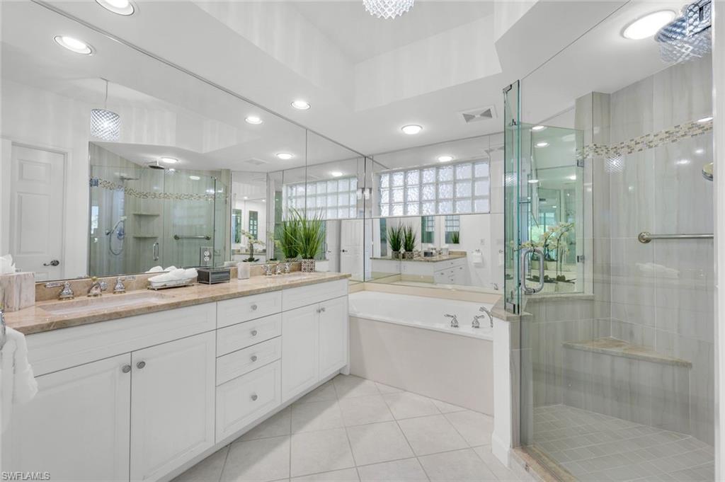 315 Dunes Boulevard, Unit 201 Naples, FL 34110 - Photo 12 of 30 a bathroom with a shower sink and mirror