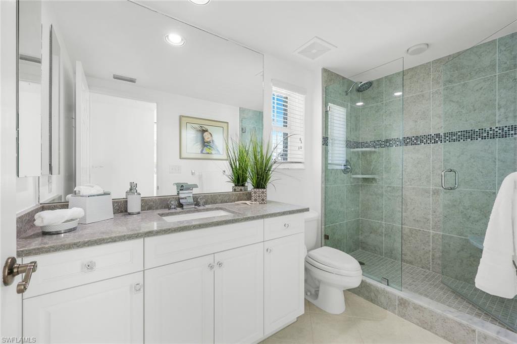 315 Dunes Boulevard, Unit 201 Naples, FL 34110 - Photo 14 of 30 a bathroom with a granite countertop sink a toilet and shower