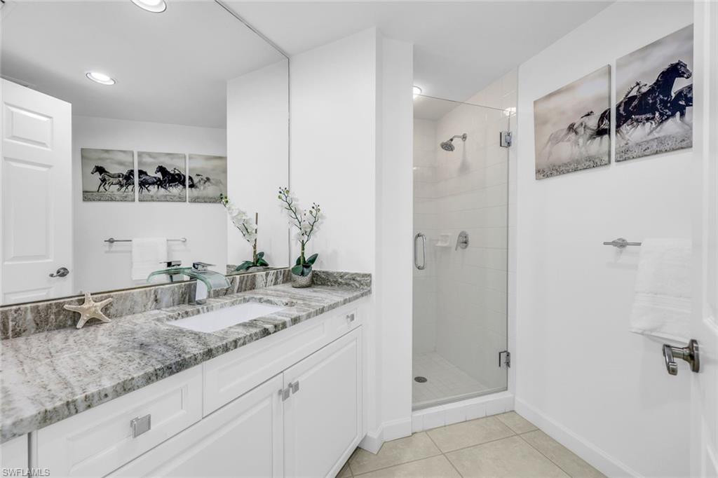 315 Dunes Boulevard, Unit 201 Naples, FL 34110 - Photo 16 of 30 a bathroom with a granite countertop sink two mirror and shower