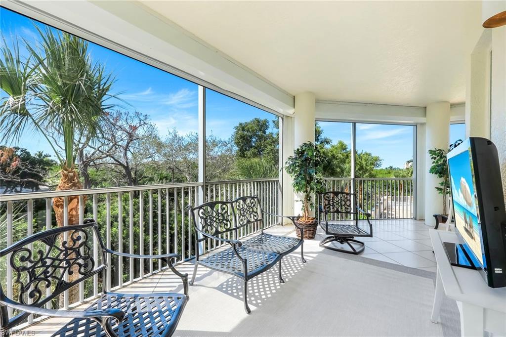 315 Dunes Boulevard, Unit 201 Naples, FL 34110 - Photo 20 of 30 a view of a chair and tables in the balcony