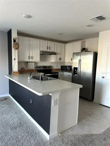 a kitchen with stainless steel appliances granite countertop a refrigerator a stove a sink and a refrigerator