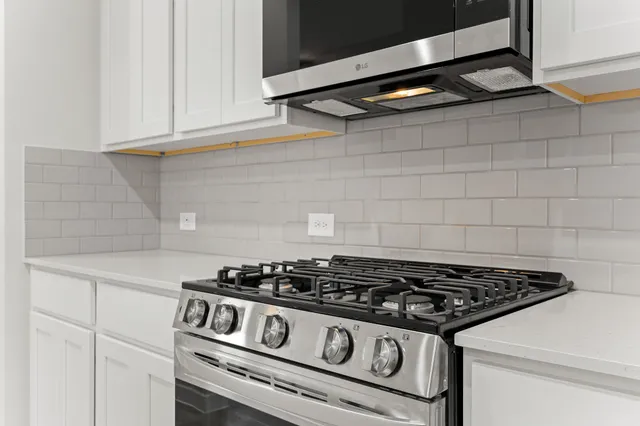 a stove top oven sitting inside of a kitchen