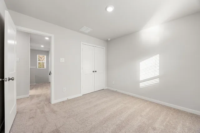 an empty room with windows and closet
