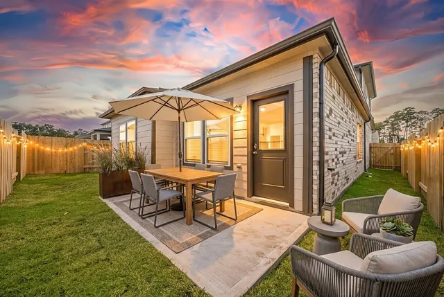 a view of a patio with table and chairs potted plants and a large tree