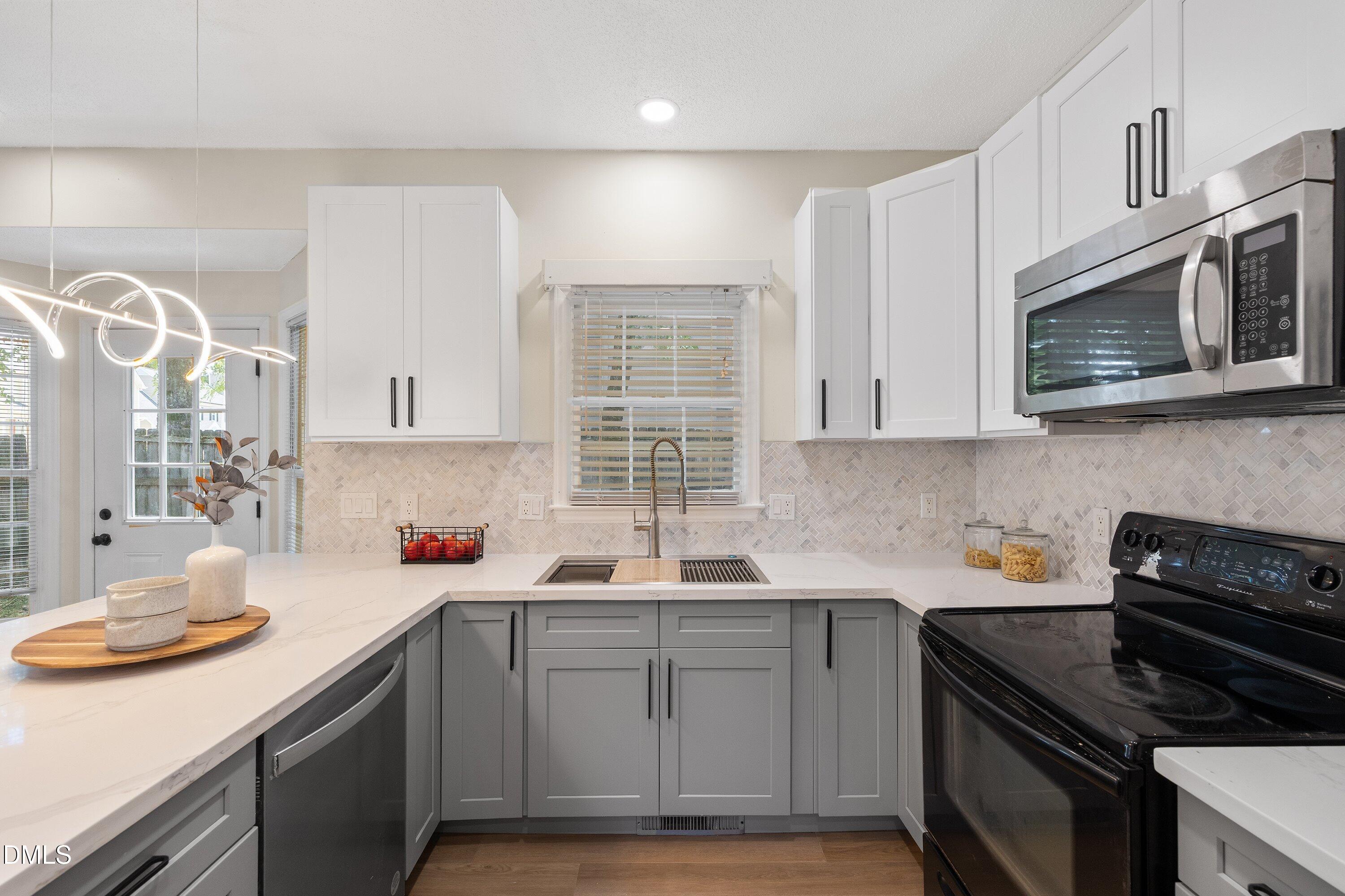 2517 Birchford Court Raleigh, NC 27604 - Photo 28 of 63 a kitchen with stainless steel appliances granite countertop a sink stove top oven and cabinets