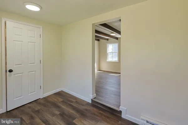 an empty room with wooden floor and a window