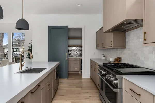 a kitchen with stainless steel appliances a sink a stove and cabinets