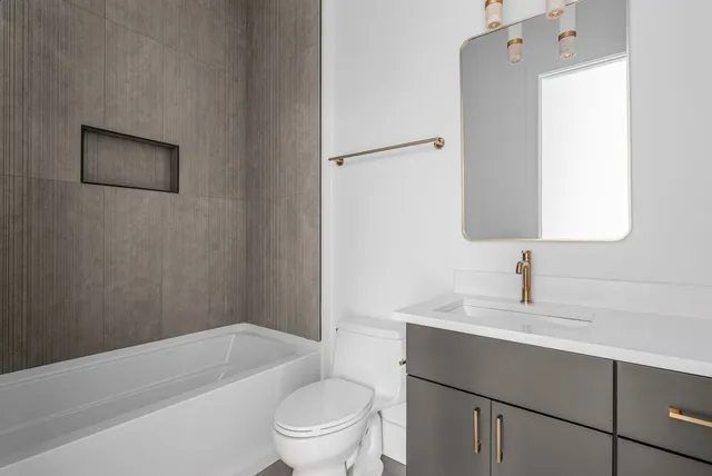 a bathroom with a sink toilet vanity and bathtub