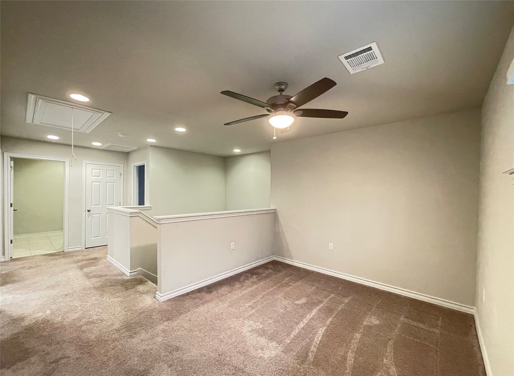 1602 Jacey Way Austin, TX 78725 - Photo 16 of 33 Carpeted open loft space featuring a ceiling fan with integrated lighting, recessed lighting, and a white painted half-wall railing