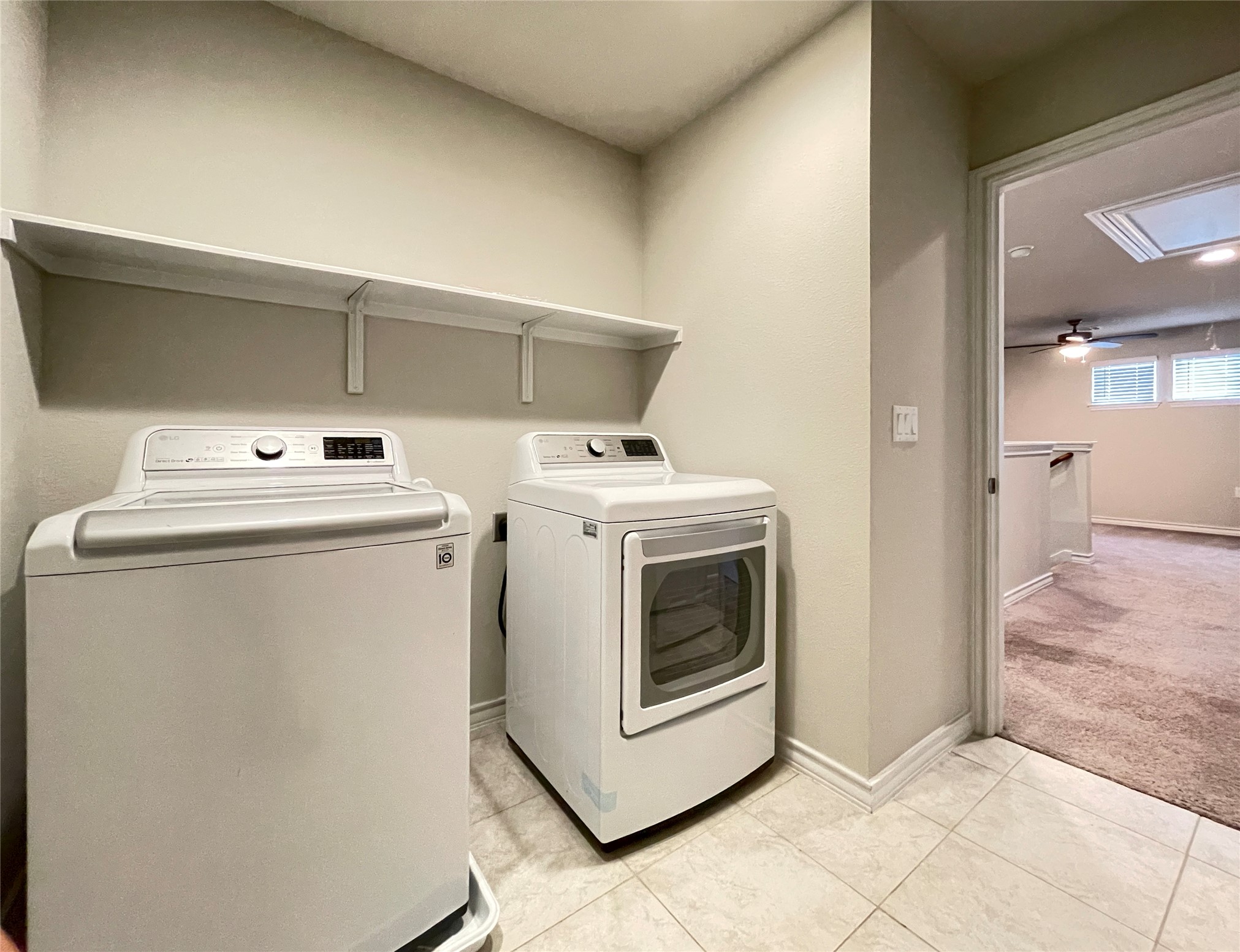 1602 Jacey Way Austin, TX 78725 - Photo 31 of 33 Dedicated laundry area featuring tile flooring, neutral wall tones, and an overhead storage shelf