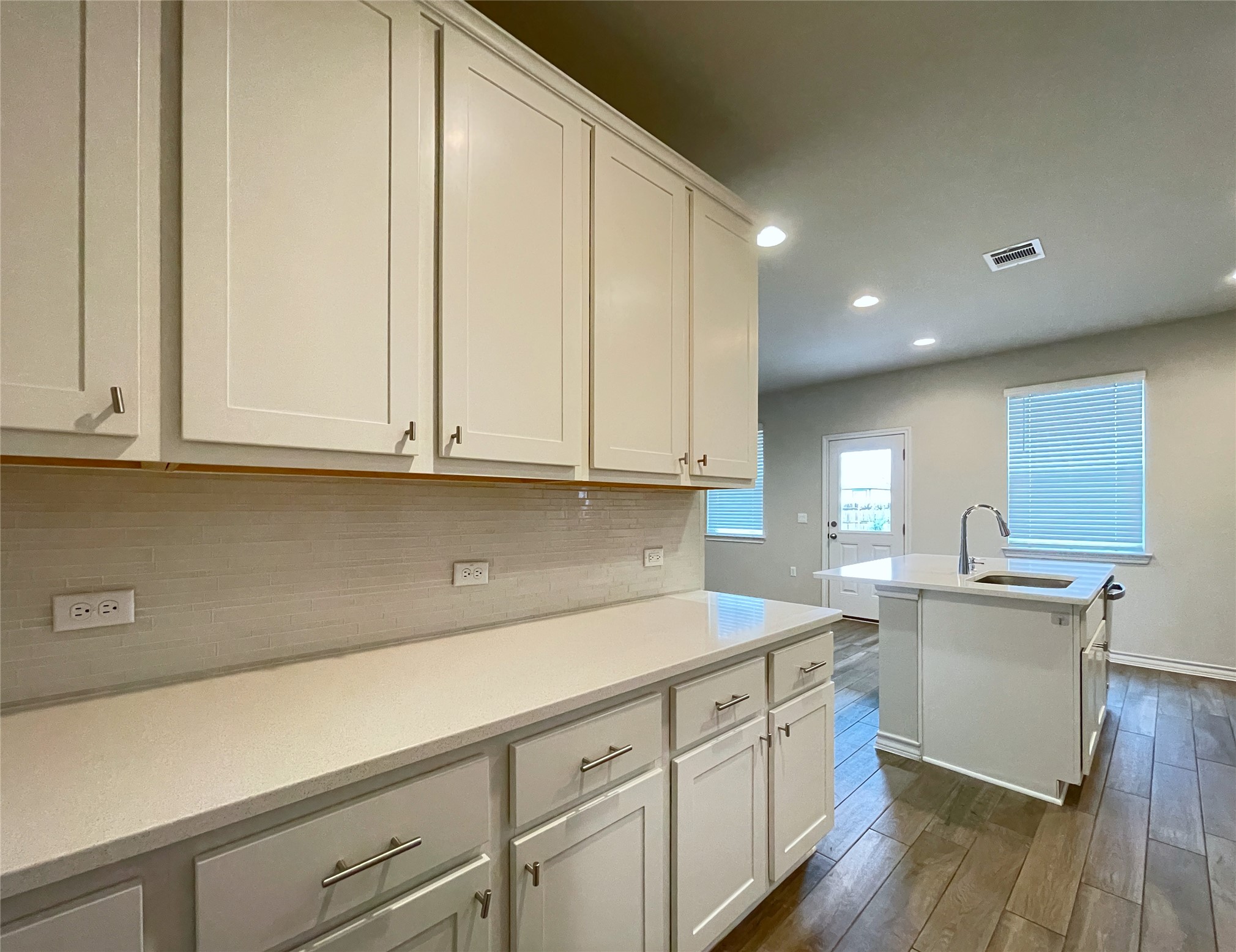 1602 Jacey Way Austin, TX 78725 - Photo 10 of 33 Kitchen featuring white shaker-style cabinetry, light-toned countertops, and a subway tile backsplash