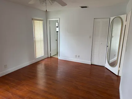 an empty room with wooden floor and mirror