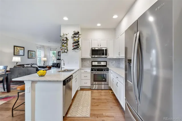 a kitchen with stainless steel appliances a stove refrigerator and a sink