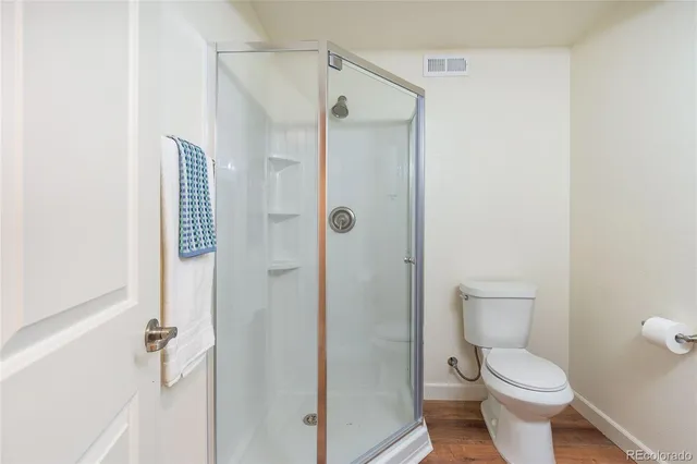 a bathroom with a toilet and a shower