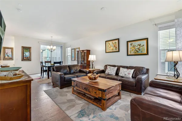 a living room with furniture wooden floor and wall paintings