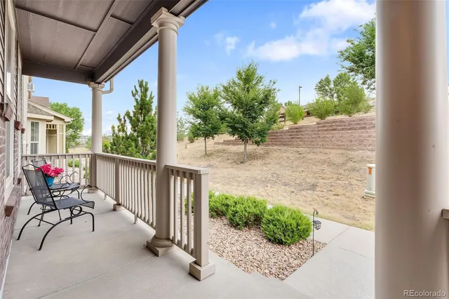 a view of a porch with chairs and potted plants
