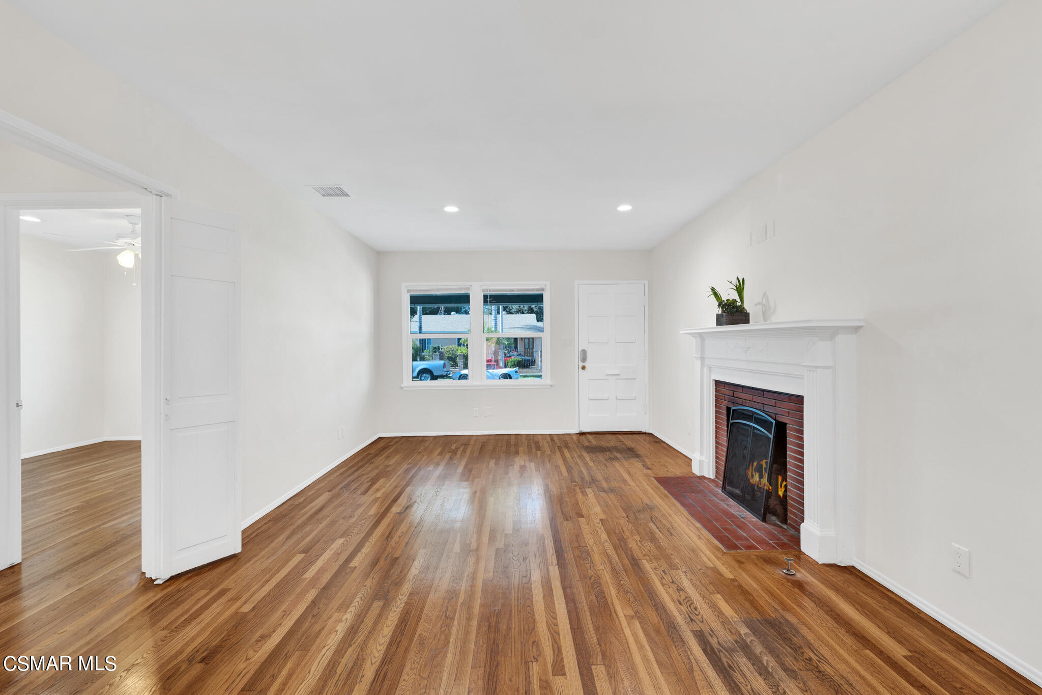 7348 Yolanda Avenue Reseda, CA 91335 - Photo 7 of 23 an empty room with wooden floor and fireplace