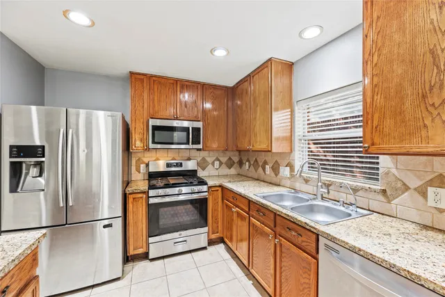 a kitchen with stainless steel appliances granite countertop a sink stove and refrigerator