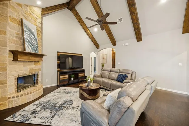 a living room with furniture a flat screen tv and a fireplace