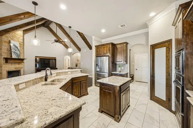 a kitchen with granite countertop a sink a counter top space appliances and cabinets