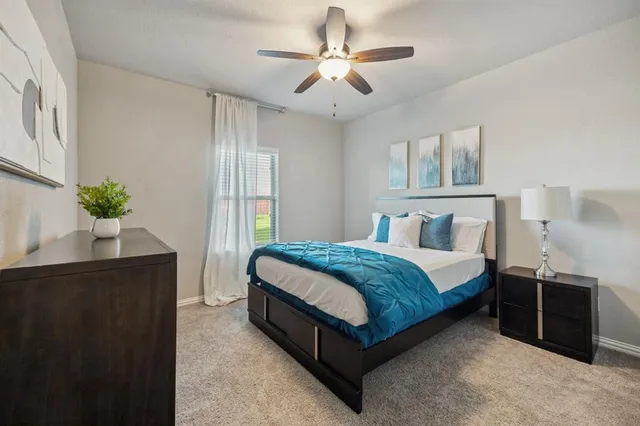 a spacious bedroom with a bed and a chandelier