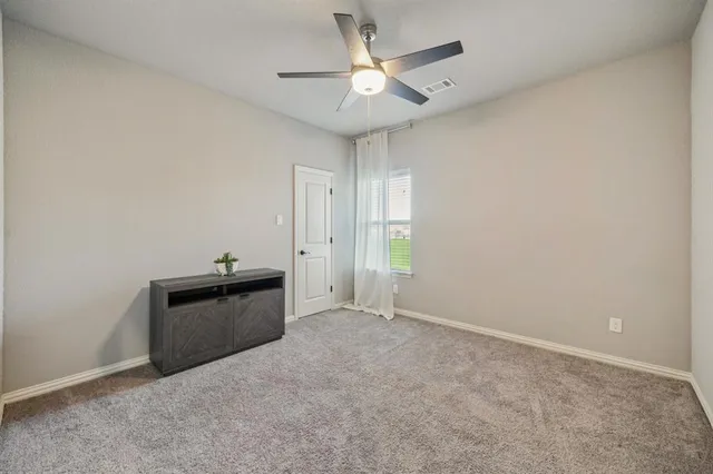 an empty room with chandelier fan