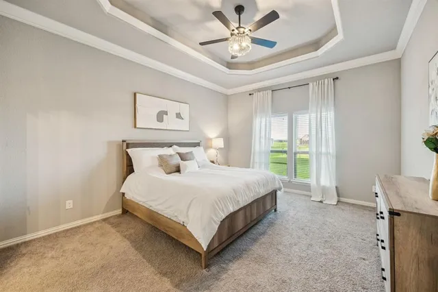 a spacious bedroom with a bed and a chandelier