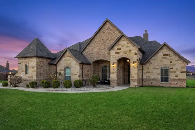 a front view of a house with a garden and plants