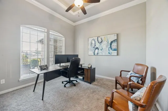 a view of a workspace with furniture and a window