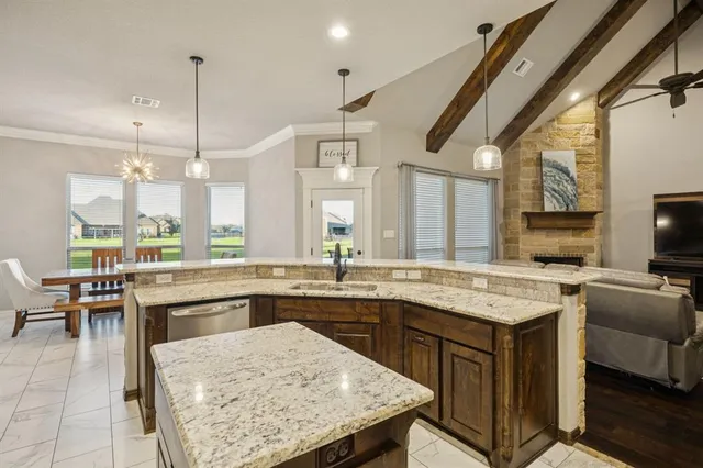 a kitchen with a stove a sink a kitchen island with chairs and wooden floor