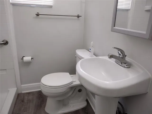 a bathroom with a sink a toilet and a mirror