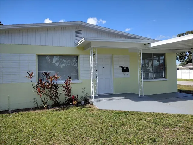 a view of a house with backyard and a garden