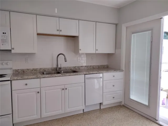 a kitchen with cabinets appliances a sink and a counter top