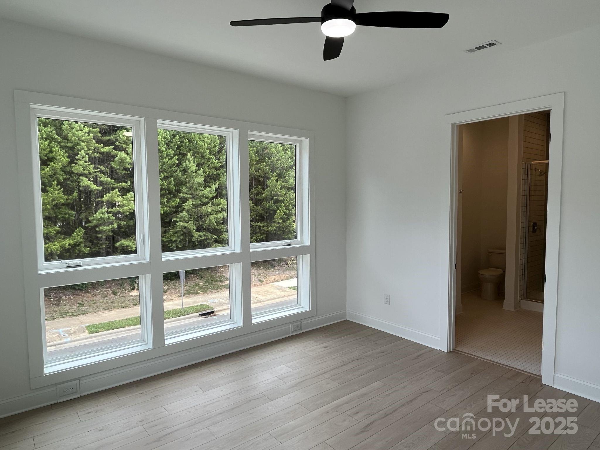 19546 Greentree Way, Unit 201 Cornelius, NC 28031 - Photo 19 of 31 an empty room with wooden floor fan and windows