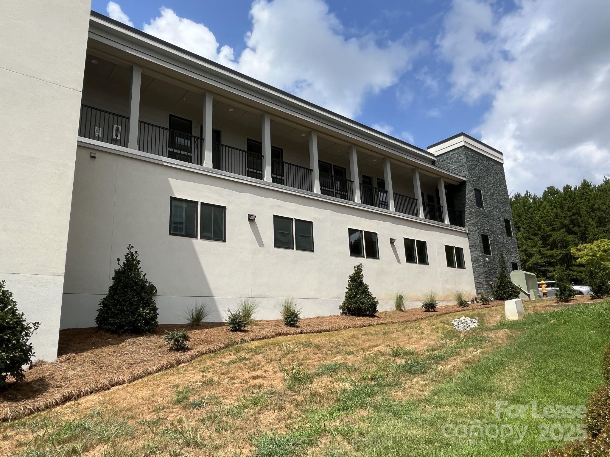 19546 Greentree Way, Unit 201 Cornelius, NC 28031 - Photo 2 of 31 a front view of a house with a yard
