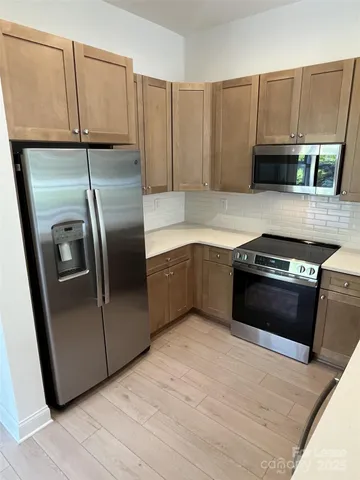 a kitchen with granite countertop a refrigerator and a sink