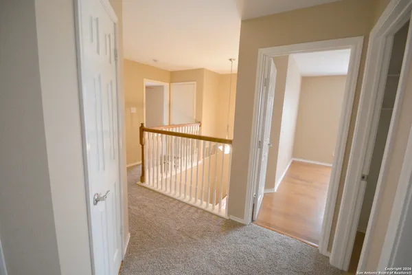 a view of a hallway with wooden floor and door