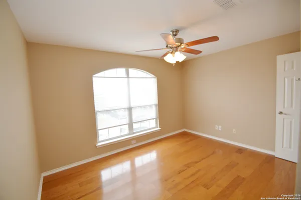 an empty room with windows and fan