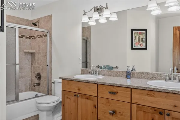 a bathroom with a granite countertop sink a toilet and a mirror
