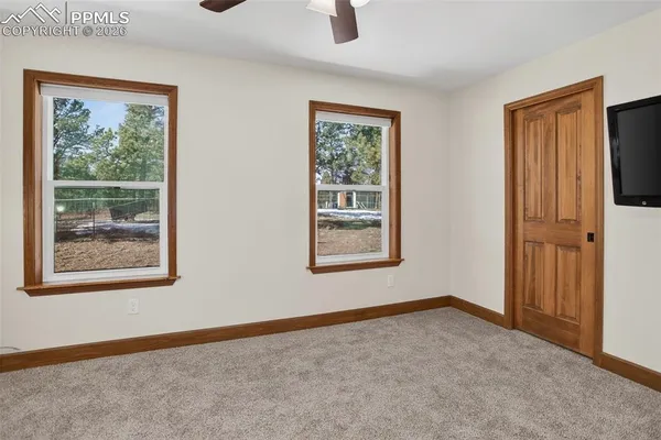a view of an empty room with windows and closet