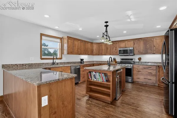 a kitchen with granite countertop a sink cabinets and stainless steel appliances