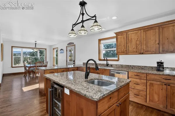 a kitchen with granite countertop a table chairs stove and wooden floor