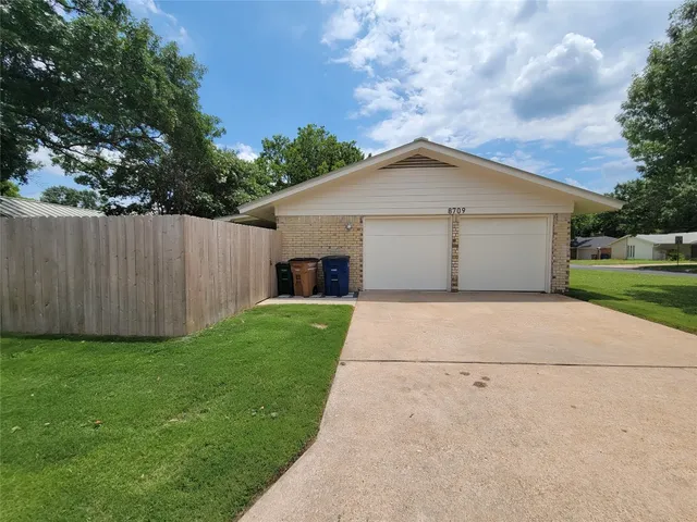 a view of a house with a yard and a large tree