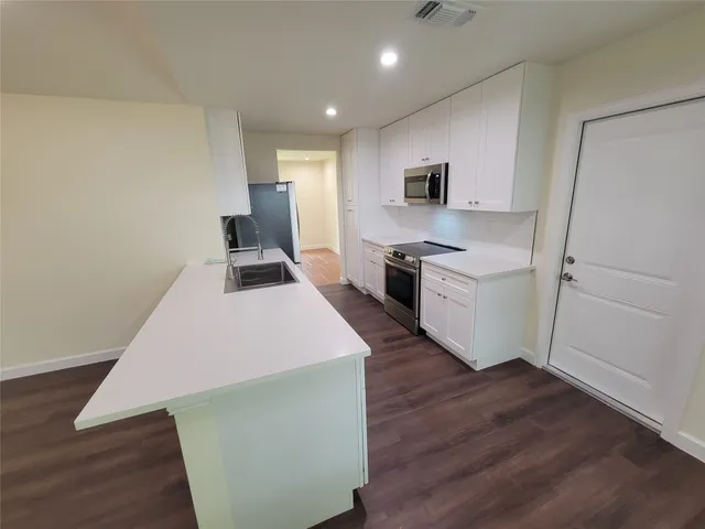 a kitchen with a refrigerator and a stove top oven