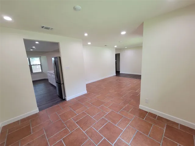 a view of a hall with wooden floor and a rug