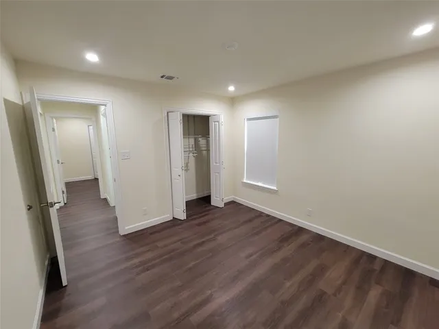 an empty room with wooden floor and mirror