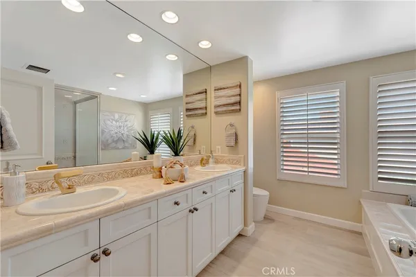 a bathroom with a double vanity sink a mirror and a bathtub