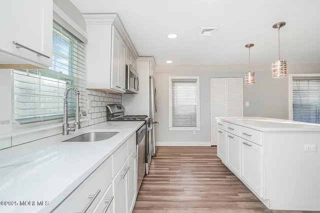 a kitchen with a sink stove and cabinets