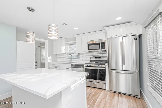 a kitchen with stainless steel appliances a sink stove and cabinets