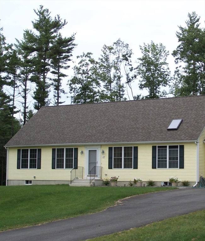 a front view of a house with a garden and yard